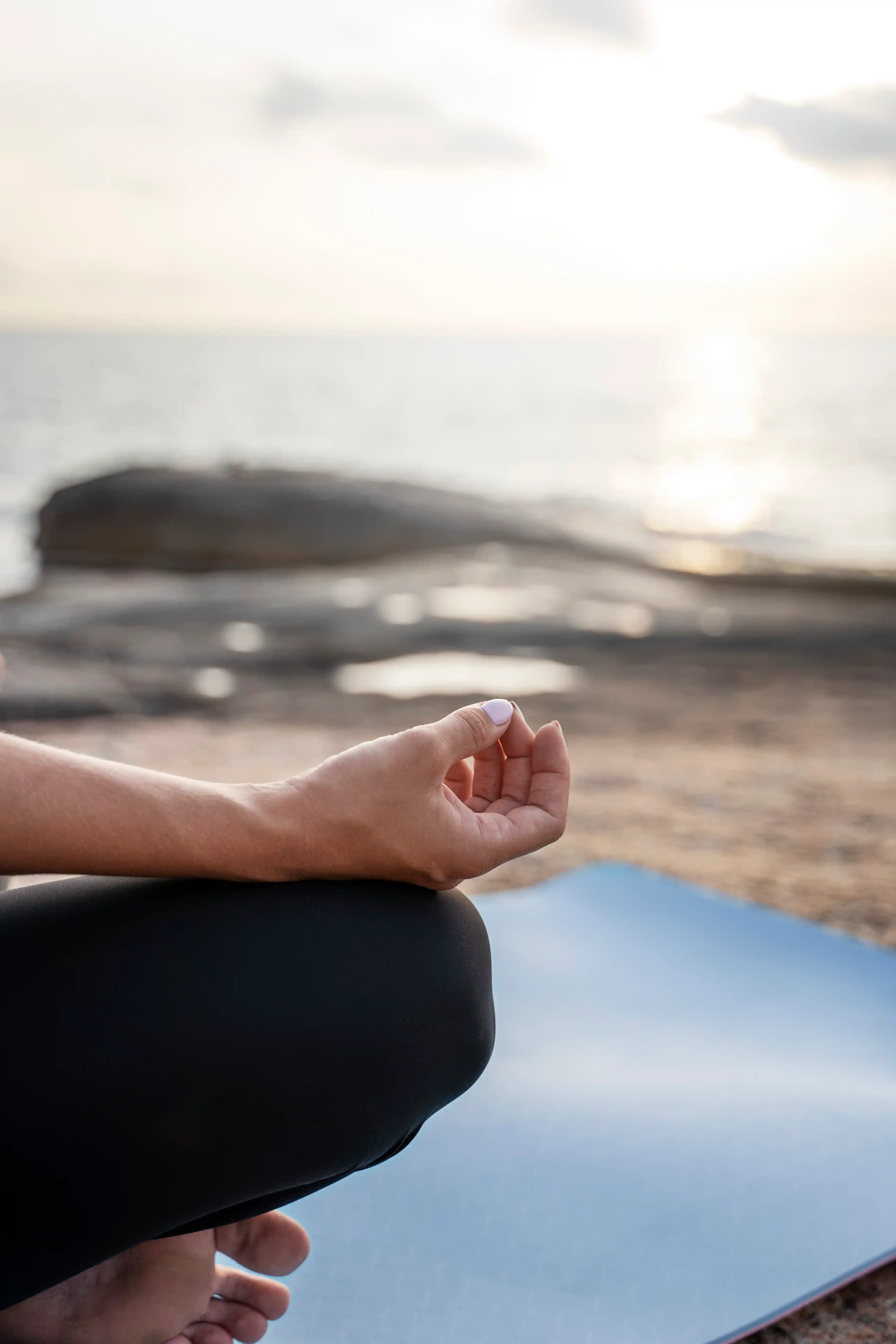 Persona meditando en la playa